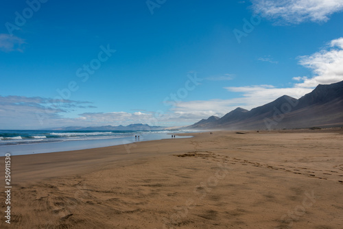 Cofete beach, Jandia peninsula, Fuerteventura, Canary Islands. Footprints on the sand and high mountains on the shore. 