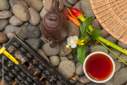 Chinese tea set, abacus, Chinese fan, flowers placed on granite blocks photo