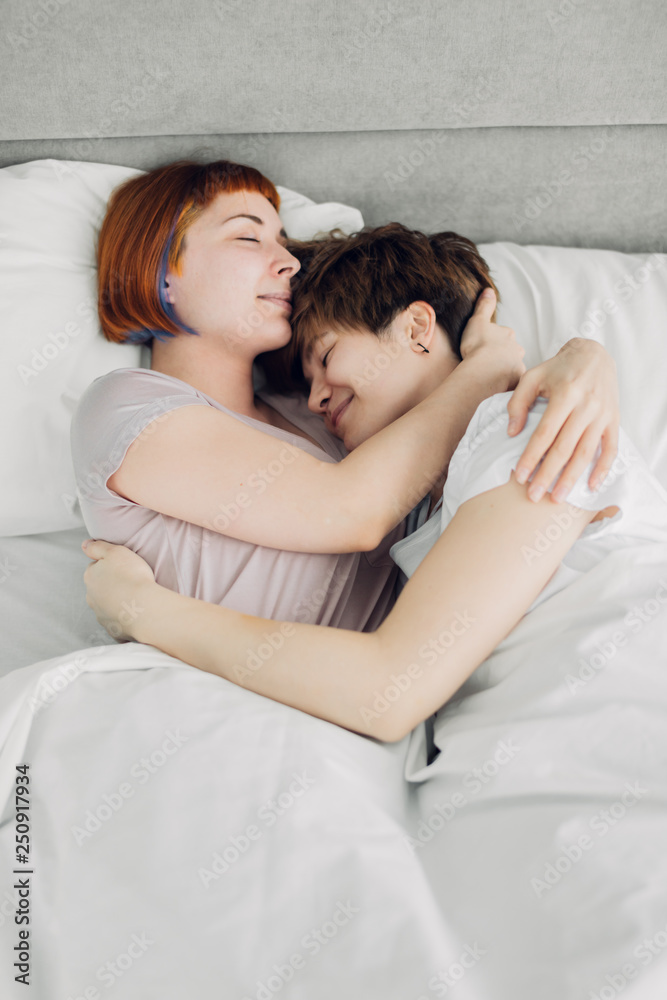 two gorgeous funny girls hugging in the bed. close up photo. emotion, feeling. close up top view photo two gorgeous funny girls hugging in the bed. close up photo. emotion, feeling. close up top view photo