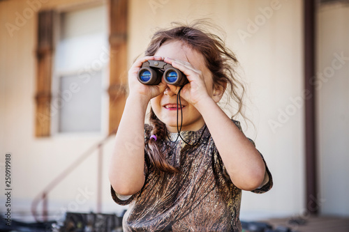 Girl (6-7) looking through binoculars  photo