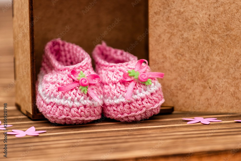 decoration with pink baby shoe, wooden background decoration with pink baby shoe, wooden background