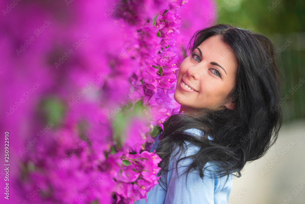 Naklejka premium Outdoor fashion photo of beautiful young woman surrounded by flowers. Spring blossom
