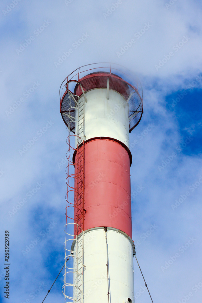 Thick white smoke from a high industrial plant chimney against the blue sky. Photo in perspective Thick white smoke from a high industrial plant chimney against the blue sky. Photo in perspective