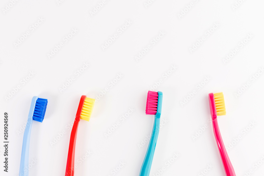 Red, pink, blue and light blue toothbrushes. Taking care of teeth, dental concept. Flat lay photo, copy space, top view Red, pink, blue and light blue toothbrushes. Taking care of teeth, dental concept. Flat lay photo, copy space, top view