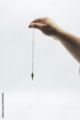 Pendulum dowsing on an isolated white background with a silver point.