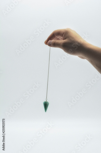 Fotografía Pendulum dowsing on an isolated white background with a turquoise crystal