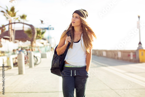 Young woman walking along promenade 