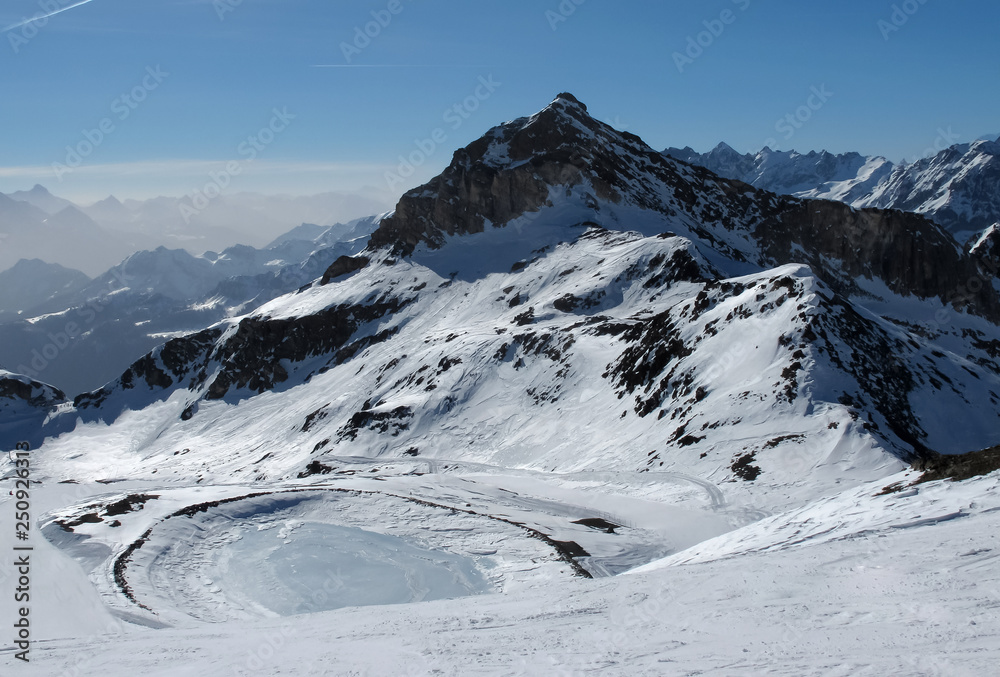 European mountains landscape, Alps, Italy, mountain skiing resort, picturesque view with deep blue sky, high rock peaks on horizon, forest trees, white ice snow surface at sunny day. Tourism, travel