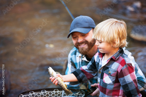 Father and son fishing in stream  photo