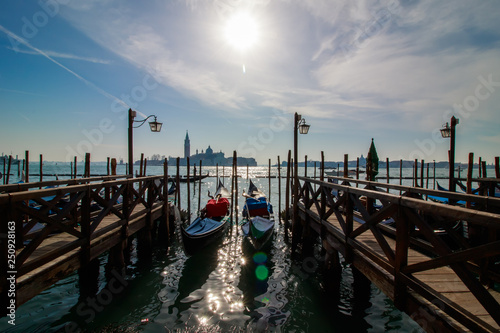 Venice italian city view with gondolas parked at seashore, channels and bridges, sea and clouds sky landscape at sunny day in Italy, tourism and travelling, travel tourist destination famous landmark