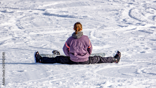 The girl-skier sits on a twine in the snow
