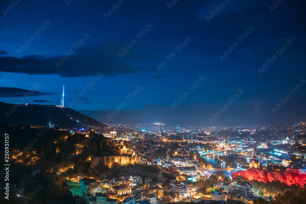 Fototapeta premium Tbilisi, Georgia. Top View Of Georgian Capital City Skyline Cityscape In Night Illuminations. Georgian Capital Skyline Cityscape