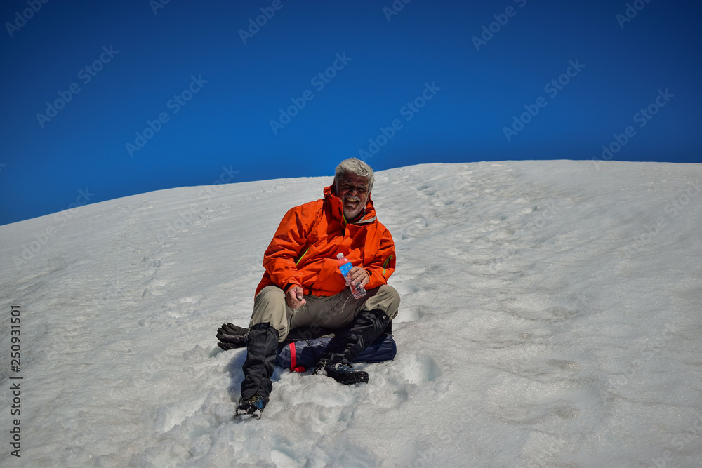hombre adulto descansando en una montaña nevada