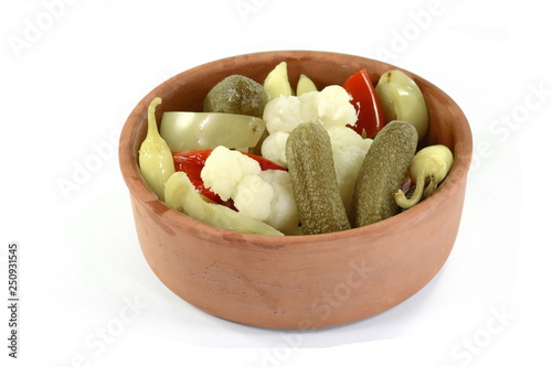 Mixed pickled in ceramic bowl isolated on white. photo