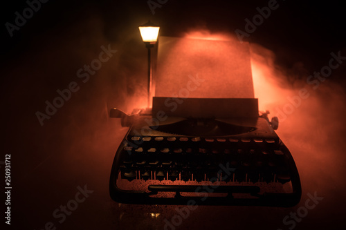 Old fashion typewritter on dark foggy background. Close up of vintage typewritter machine photo