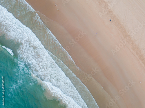 Top down aerial view of clean beach coastline.