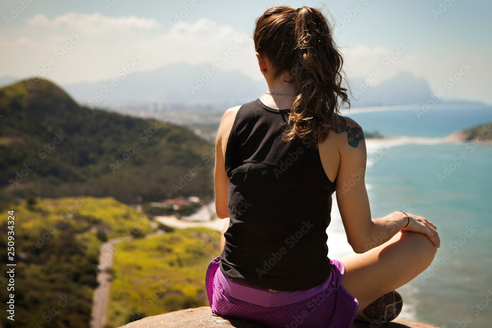 Woman sitting on rock by sea Woman sitting on rock by sea