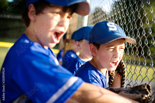 Little league players (8-9) cheering from dugout 