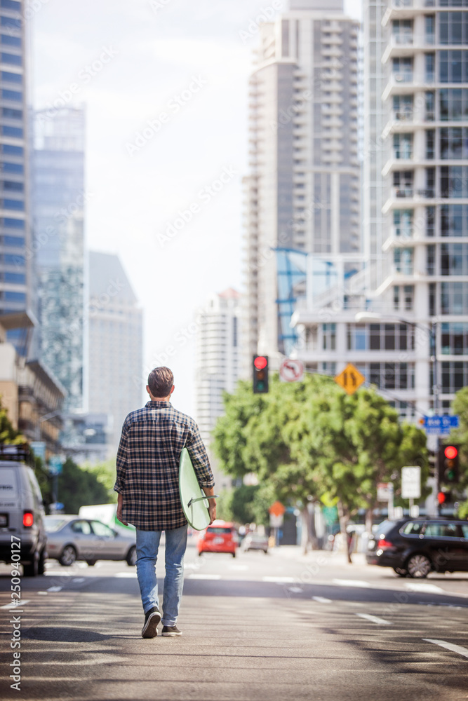 Man with surfboard in middle of street Man with surfboard in middle of street