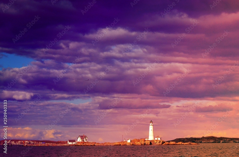 Lighthouse outside of Boston harbor with purple clouds