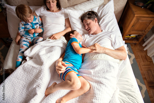 Boy (2-3, 4-5) with parents in bed  photo