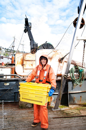 Fisherwoman holding crates with crabs on boat  photo