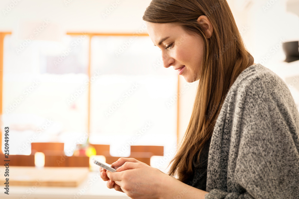 Side-view of young woman texting Side-view of young woman texting