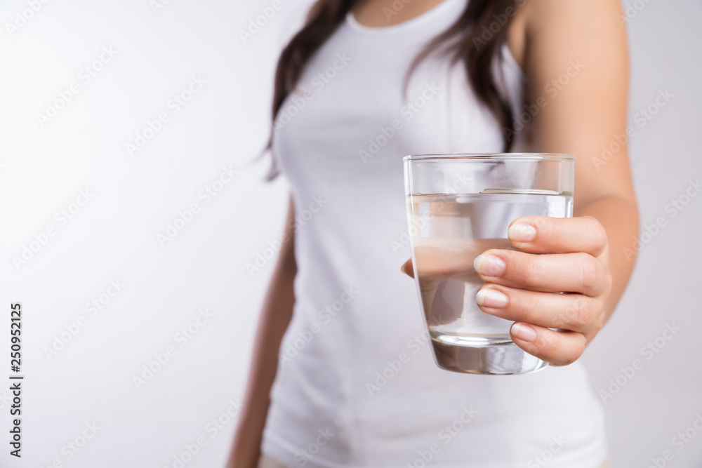 A glass of clean mineral water in woman's hands. Concept of environment protection, healthy drink and healthcare. A glass of clean mineral water in woman's hands. Concept of environment protection, healthy drink and healthcare.