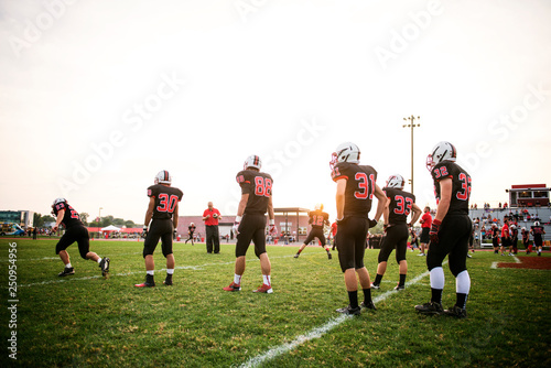 Football players (14-15, 16-17) training on playing field  photo