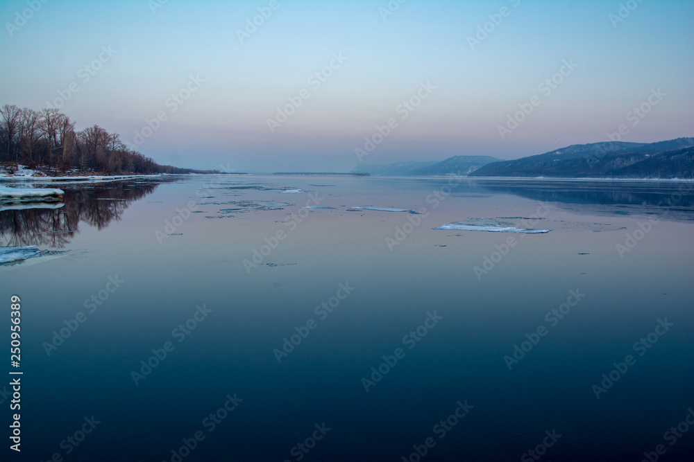 Fototapeta premium ice floats on the river at sunset
