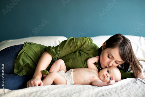 Mother kissing her baby son (2-5 months) in bed 