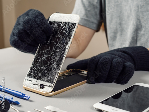 Technician or engineer opening broken smartphone for repair or replace new part on desk