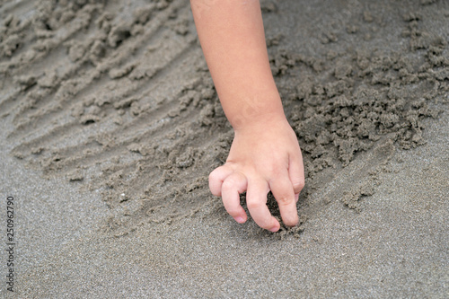 close up kid's hand and fingers, play and learn at the beach.