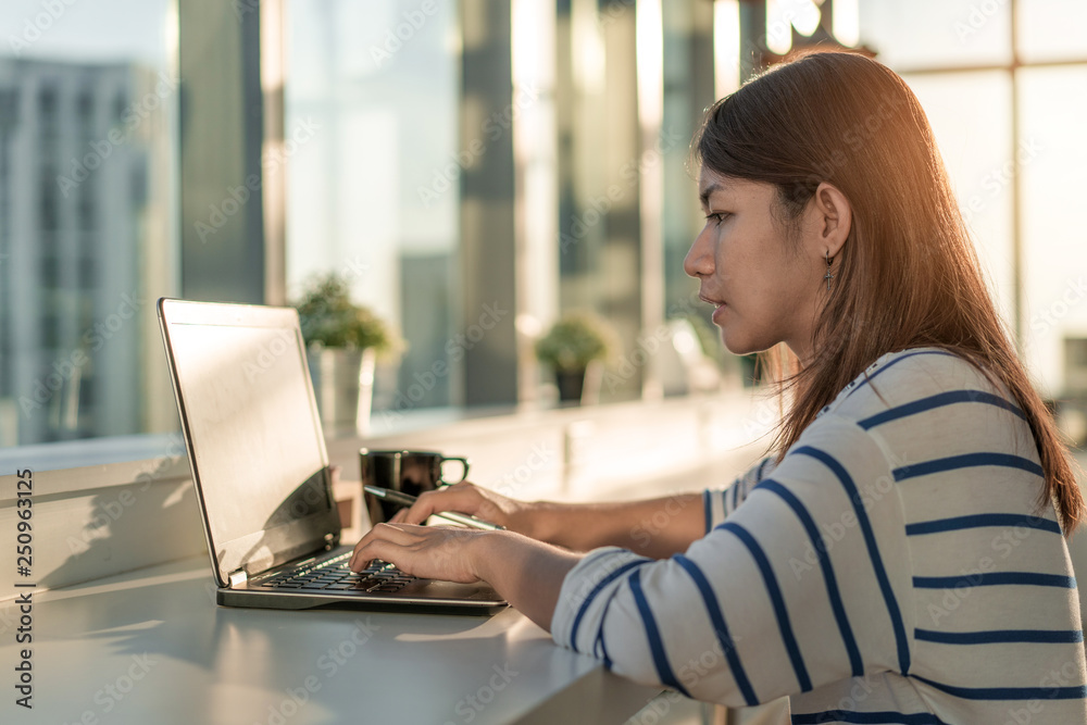 Young asia woman working on a laptop at home office in morning time, Selective focus. Young asia woman working on a laptop at home office in morning time, Selective focus.
