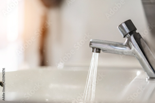 Close up of wash basin with water being poured in bathroom, Selective focus.