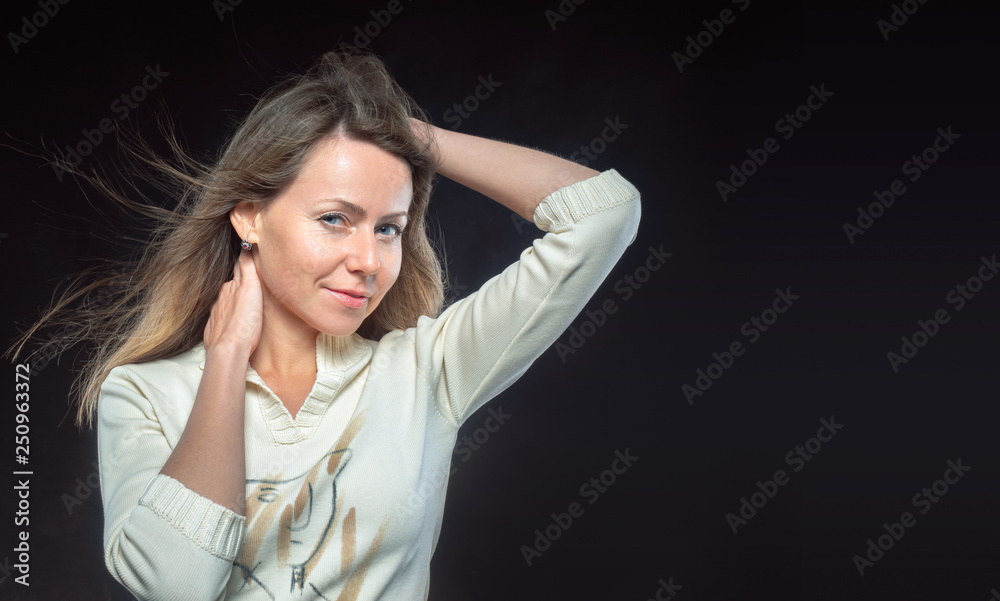 Attractive woman with hair fluttering in the wind and leer looks on ...