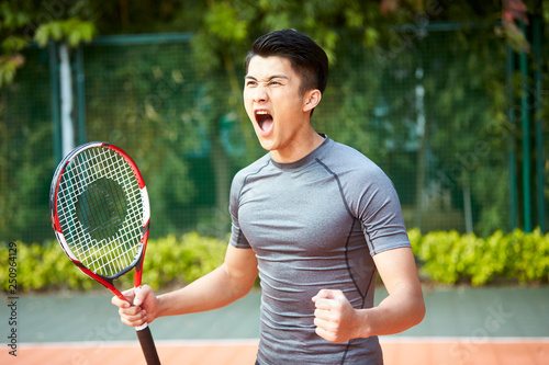 young asian male tennis player celebrating success