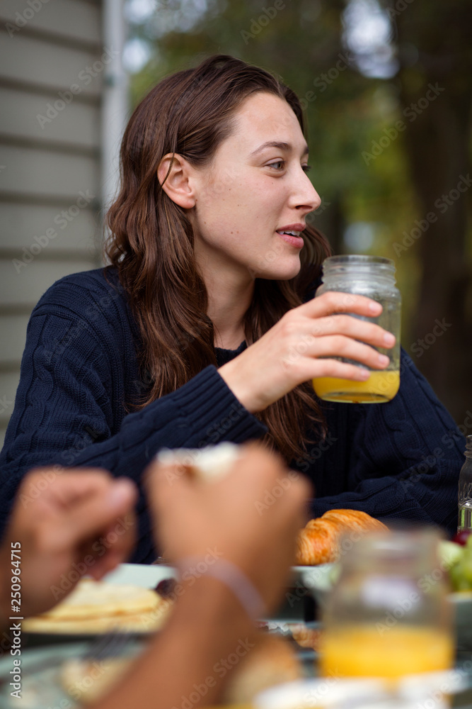 Young woman with juice in jar at table outdoor Young woman with juice in jar at table outdoor