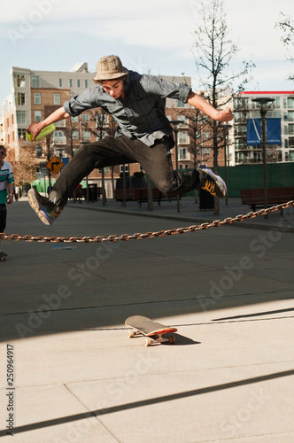 Skateboarder jumping over chain 