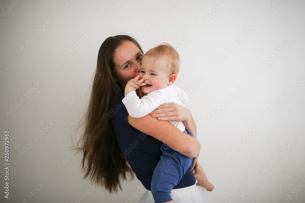 mother holding baby in her arms, hugs son and kiss mother holding baby in her arms, hugs son and kiss