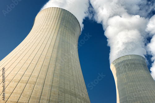 power plant cooling towers steaming on dark blue sky background photo