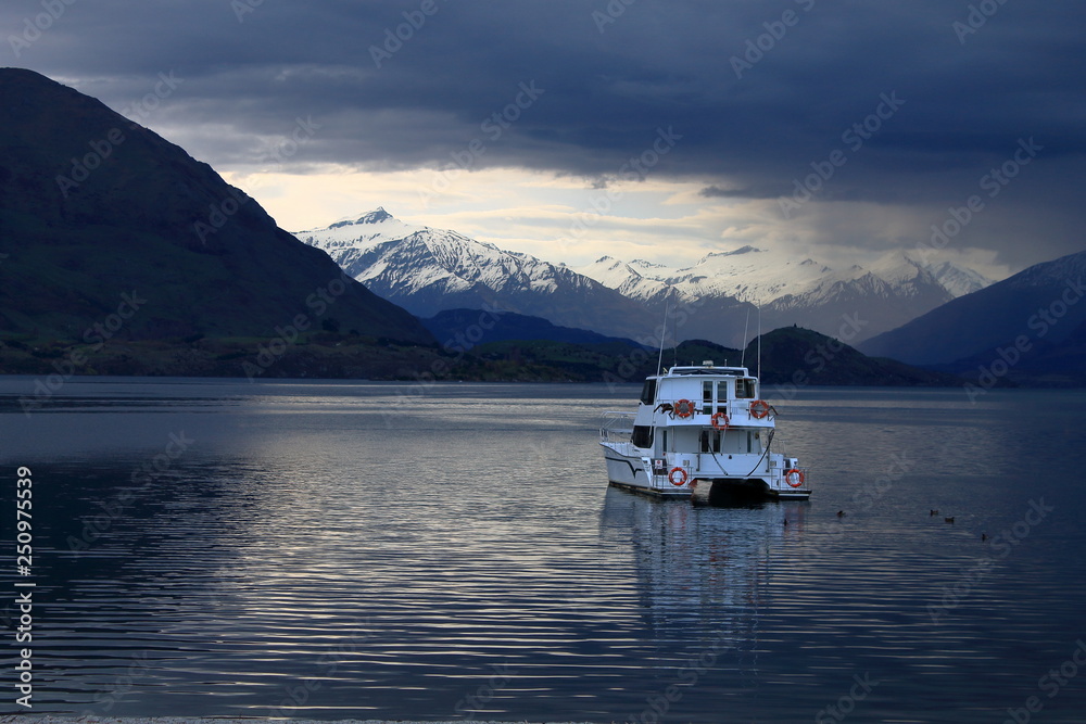Boat swimming on lake wanaka on a moody day Boat swimming on lake wanaka on a moody day