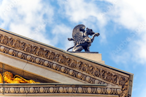 Sculpture griffin on the pediment of the building of the former Volga-Kama Bank in Samara against the blue sky.