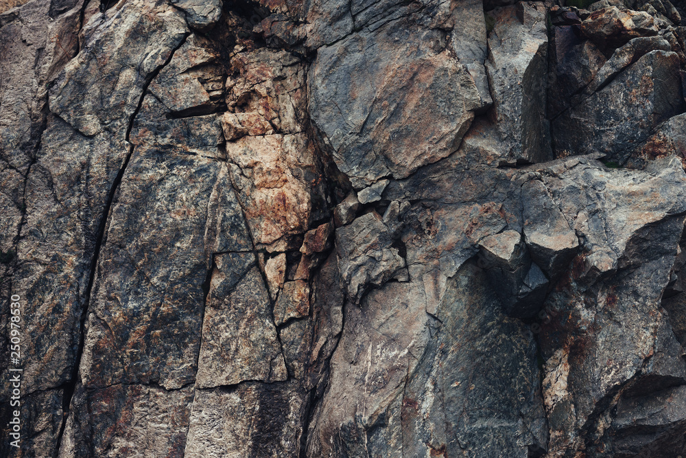 Fragment of a rock in the mountains, destroyed in cracks close-up, dark and brown Fragment of a rock in the mountains, destroyed in cracks close-up, dark and brown