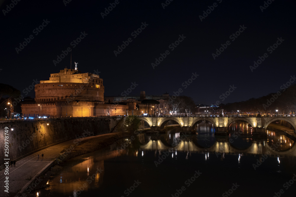 Rome Italy. Beautiful view of Castel Sant'Angelo and the bridge at night with reflections on the Tiber river.