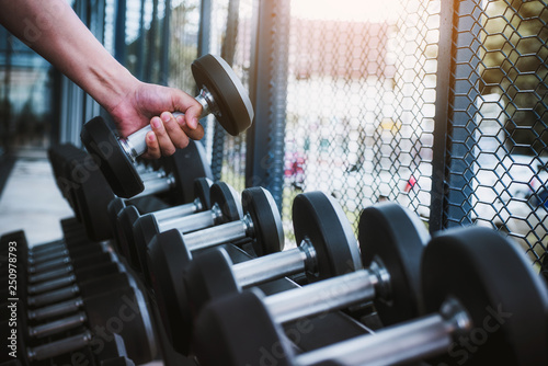 Close up of hand exercise man with dumbbell for flexing muscles in gym. healthy lifestyle Concept .