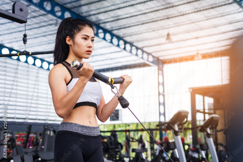 Fototapeta premium fitness woman exercise workout with exercise-machine Cable in fitness gym. healthy lifestyle Concept