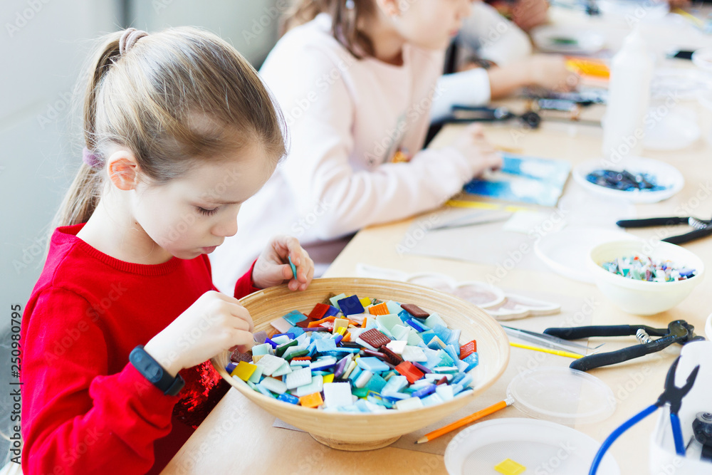 The girl is engaged in creating a mosaic in a creative workshop. The girl is engaged in creating a mosaic in a creative workshop.