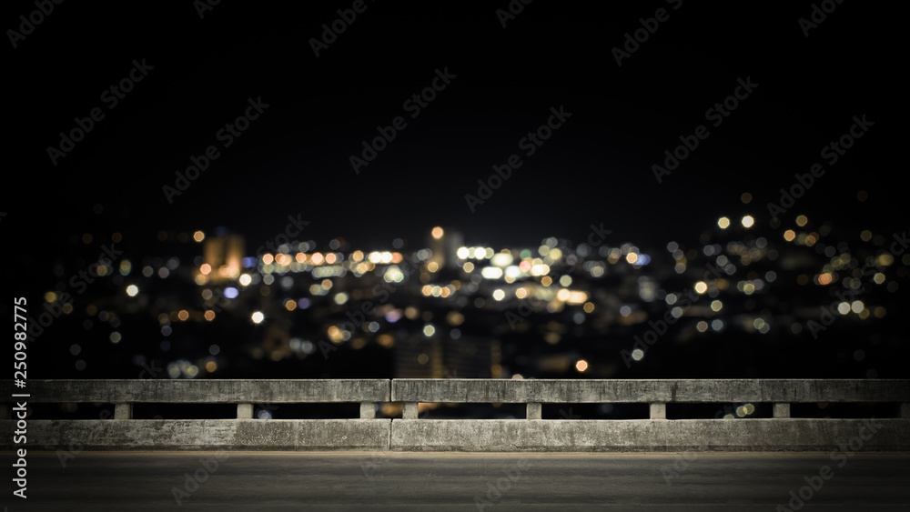 View from empty concrete bridge above the town at night.