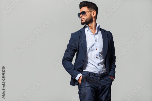 Elegant young handsome man in suite wearing glasses. Studio fashion portrait.